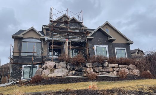 Surgical stucco cutback and window prep in North Salt Lake UT showing 5-inch scoring and exposed water barriers for Pella window integration.