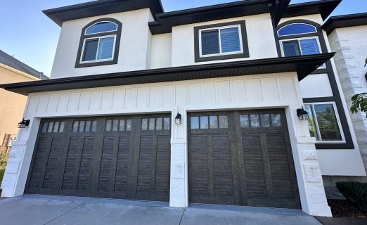 Artisan stucco resurfacing in Holladay, UT featuring a smooth white Senergy finish, high-contrast black soffit and fascia, and custom-engineered stucco board-and-batten trimming around the garage.